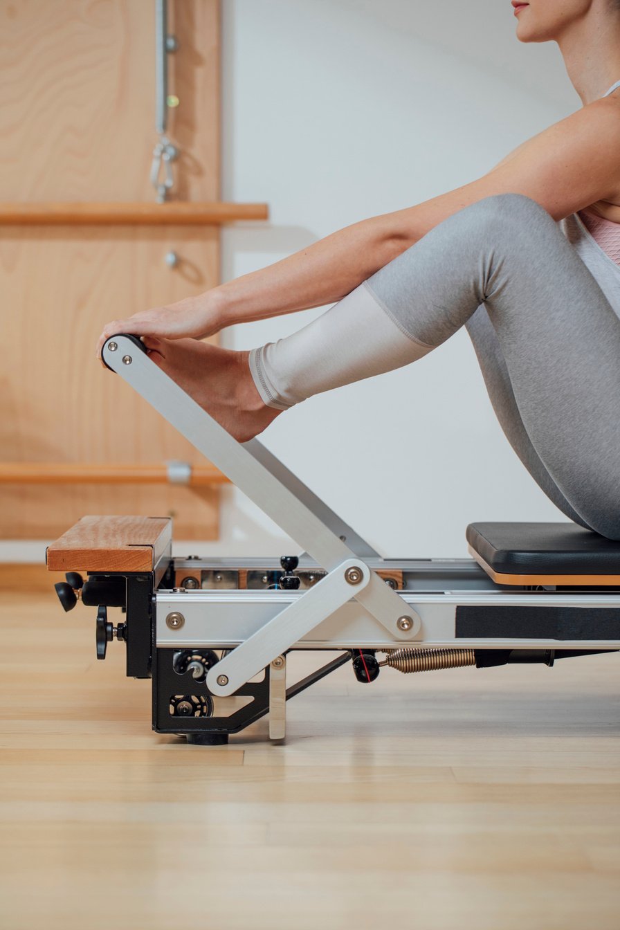 Sportswoman Doing Exercise on Pilates Reformer